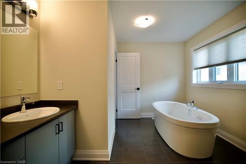 Full bathroom featuring vanity, a freestanding tub, and dark tile patterned flooring - 559 Balsam Poplar Street, Waterloo, ON - Indoor Photo Showing Bathroom