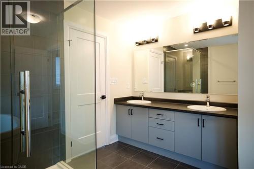 Bathroom featuring a stall shower, double vanity, and dark tile patterned floors - 559 Balsam Poplar Street, Waterloo, ON - Indoor Photo Showing Bathroom