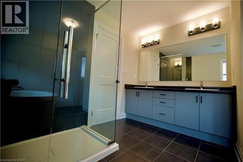 Full bathroom with a stall shower, double vanity, and dark tile patterned floors - 559 Balsam Poplar Street, Waterloo, ON - Indoor Photo Showing Bathroom