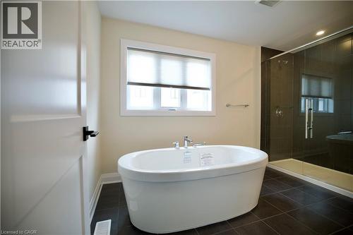 Bathroom with a soaking tub, a shower stall, and dark tile patterned flooring - 559 Balsam Poplar Street, Waterloo, ON - Indoor Photo Showing Bathroom
