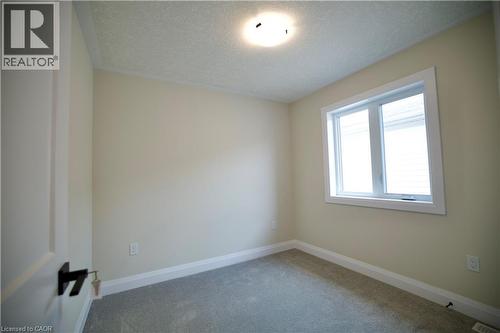 Spare room featuring a textured ceiling and carpet flooring - 559 Balsam Poplar Street, Waterloo, ON - Indoor Photo Showing Other Room