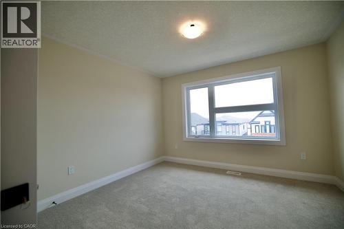 Empty room with a textured ceiling and light colored carpet - 559 Balsam Poplar Street, Waterloo, ON - Indoor Photo Showing Other Room
