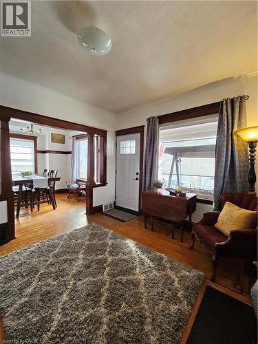 Foyer with a textured ceiling, wood finished floors, suspended lighting, and ornamental molding - 253 Grosvenor Avenue S, Hamilton, ON - Indoor