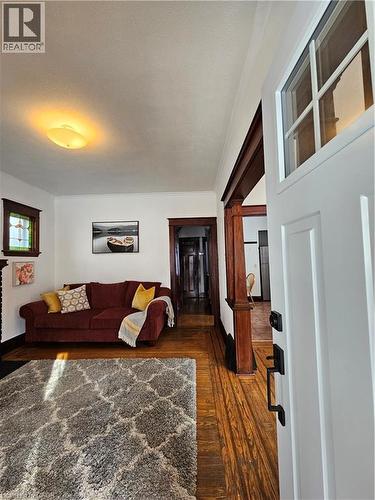 Living area with dark wood-type flooring and baseboards - 253 Grosvenor Avenue S, Hamilton, ON - Indoor