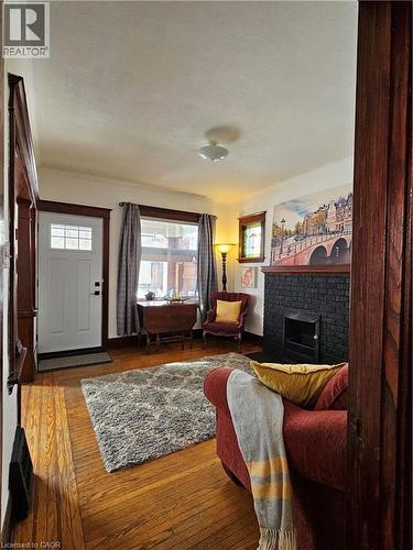 Living area with wood-type flooring and a fireplace - 253 Grosvenor Avenue S, Hamilton, ON - Indoor Photo Showing Living Room With Fireplace
