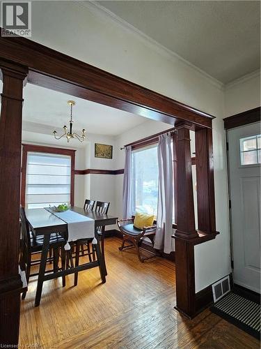 Dining room with hardwood / wood-style floors, ornamental molding, hanging lights, and ornate columns - 253 Grosvenor Avenue S, Hamilton, ON - Indoor