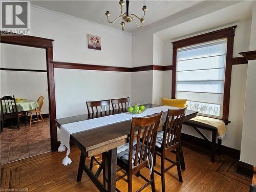 Dining space featuring ornamental molding, suspended lighting, and wood finished floors - 253 Grosvenor Avenue S, Hamilton, ON - Indoor Photo Showing Dining Room