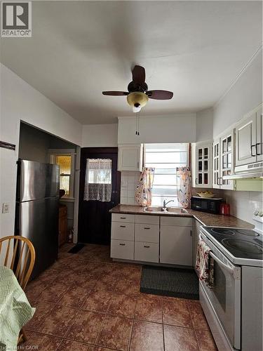 Kitchen featuring black appliances, dark countertops, white cabinetry, and ceiling fan - 253 Grosvenor Avenue S, Hamilton, ON - Indoor Photo Showing Kitchen With Double Sink