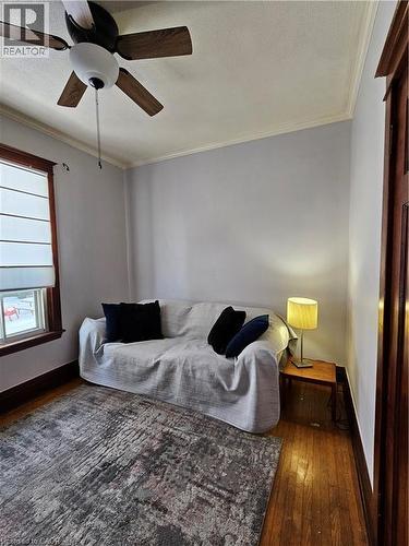Living area featuring dark wood-type flooring, ceiling fan, ornamental molding, and a textured ceiling - 253 Grosvenor Avenue S, Hamilton, ON - Indoor Photo Showing Bedroom