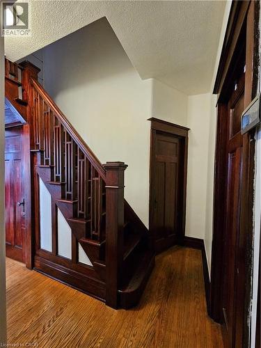 Stairs featuring wood finished floors and a textured ceiling - 253 Grosvenor Avenue S, Hamilton, ON - Indoor Photo Showing Other Room