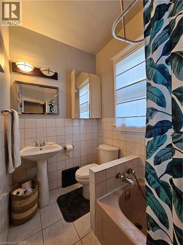 Full bathroom with tile walls, light tile patterned flooring, and wainscoting - 253 Grosvenor Avenue S, Hamilton, ON - Indoor Photo Showing Bathroom