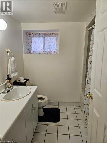 Full bathroom featuring vanity, light tile patterned flooring, and shower / bathtub combination with curtain - 253 Grosvenor Avenue S, Hamilton, ON - Indoor Photo Showing Bathroom