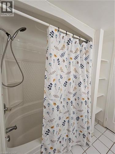 Bathroom featuring shower / bath combo with shower curtain and light tile patterned floors - 253 Grosvenor Avenue S, Hamilton, ON - Indoor Photo Showing Bathroom