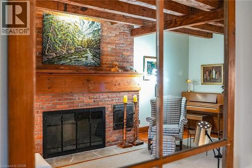 Carpeted living room featuring a fireplace and beam ceiling - 2432 Seburn Road, Fonthill, ON - Indoor With Fireplace