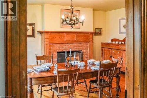 Dining room featuring wood-type flooring, a fireplace, and suspended lighting - 2432 Seburn Road, Fonthill, ON - Indoor Photo Showing Dining Room With Fireplace