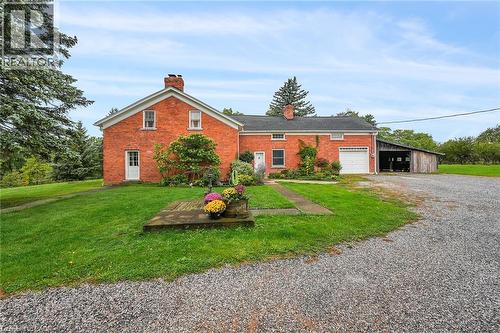 View of front of home featuring a chimney, driveway, a garage, a front lawn, and brick siding - 2432 Seburn Road, Fonthill, ON - Outdoor