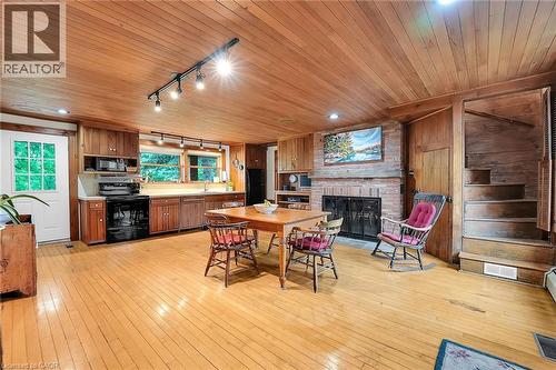 Dining area featuring rail lighting, light wood finished floors, a fireplace, wood ceiling, and wooden walls - 2432 Seburn Road, Fonthill, ON - Indoor With Fireplace