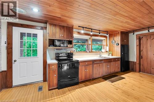 Kitchen with rail lighting, black appliances, wood finish cabinetry, wooden ceiling, and light countertops - 2432 Seburn Road, Fonthill, ON - Indoor Photo Showing Kitchen
