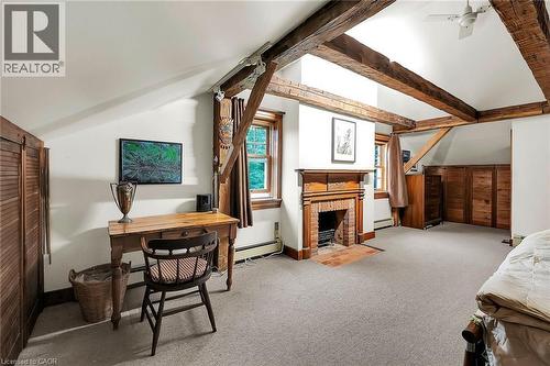 Bedroom featuring vaulted ceiling, light colored carpet, a fireplace, baseboard heating, and a baseboard radiator - 2432 Seburn Road, Fonthill, ON - Indoor With Fireplace