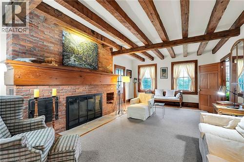 Carpeted living area with beam ceiling and a fireplace - 2432 Seburn Road, Fonthill, ON - Indoor Photo Showing Living Room With Fireplace