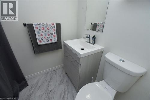 Nicely updated 2pc Bathroom featuring vanity and light marble finish flooring - 1345 Colonsay Drive, Burlington, ON - Indoor Photo Showing Bathroom