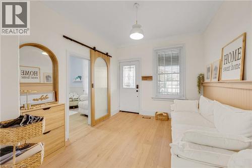 Entryway with light wood-style floors, a barn door, and ornamental molding - 6 Ben Lomond Place, Hamilton, ON - Indoor Photo Showing Other Room