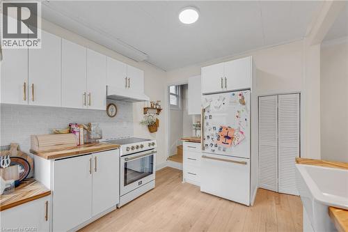 Kitchen with wood counters, white cabinetry, white appliances, light wood-style flooring, and backsplash - 6 Ben Lomond Place, Hamilton, ON - Indoor Photo Showing Kitchen