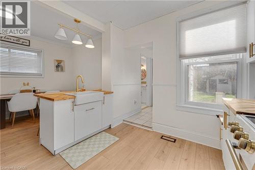 Kitchen with butcher block counters, white cabinets, stove, decorative light fixtures, and light wood-style floors - 6 Ben Lomond Place, Hamilton, ON - Indoor
