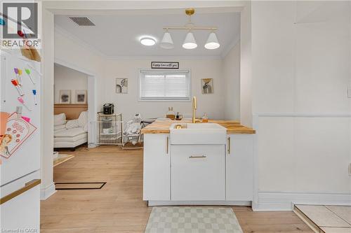Kitchen featuring freestanding refrigerator, ornamental molding, butcher block countertops, white cabinets, and light wood finished floors - 6 Ben Lomond Place, Hamilton, ON - Indoor Photo Showing Other Room