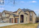View of front of property with stone siding, a shingled roof, a front lawn, and concrete driveway - 254 Rymal Road W, Hamilton, ON  - Outdoor With Facade 