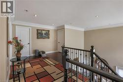 Hall with ornamental molding, an upstairs landing, dark wood-style flooring, and recessed lighting - 