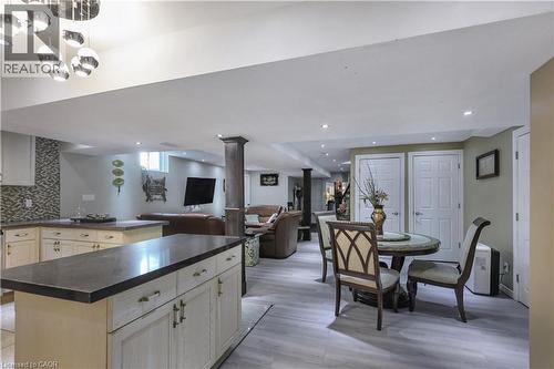 Kitchen featuring a kitchen island, open floor plan, dark countertops, tasteful backsplash, and light wood-type flooring - 254 Rymal Road W, Hamilton, ON - Indoor