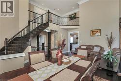Dining area with a high ceiling, crown molding, and dark wood-style flooring - 