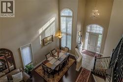 Entrance foyer featuring hanging lights, stone tile floors, and a high ceiling - 