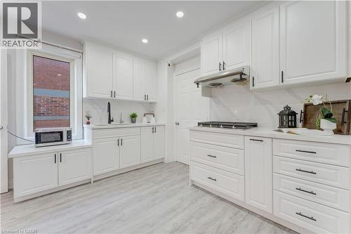 Kitchen featuring white cabinets, recessed lighting, light countertops, light wood-style floors, and stainless steel gas cooktop - 24 Onward Avenue, Kitchener, ON - Indoor Photo Showing Kitchen