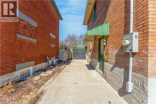 View of property exterior featuring brick siding, a garage, and an outbuilding - 24 Onward Avenue, Kitchener, ON - Outdoor With Exterior