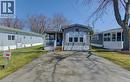 Manufactured / mobile home featuring a front lawn, driveway, and a wooden deck - 580 Beaver Creek Road Unit# 185, Waterloo, ON  - Outdoor 