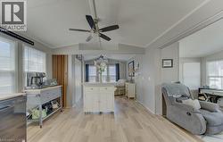 Kitchen with black dishwasher, open floor plan, light countertops, white cabinets, and light wood-style floors - 