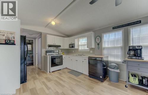 Kitchen featuring black appliances, a ceiling fan, light countertops, light wood-style floors, and white cabinetry - 580 Beaver Creek Road Unit# 185, Waterloo, ON - Indoor Photo Showing Kitchen