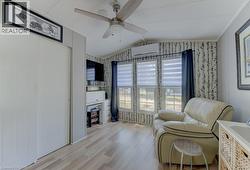 Living area with light wood-type flooring, a ceiling fan, and a mini split for heating / cooling - 