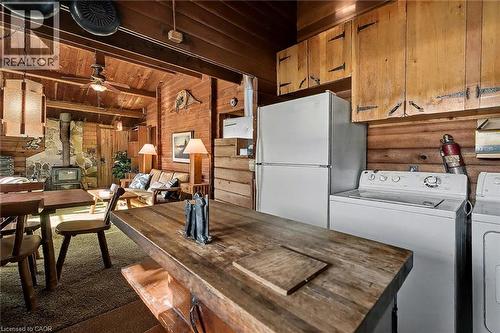 Dining space featuring a wood stove, ceiling fan, wooden walls, wooden ceiling, and dark carpet - 6361 16Th Line, Minto, ON - Indoor