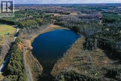 View of property location with a large body of water and a heavily wooded area - 