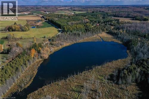 Aerial overview of property's location featuring a nearby body of water and a heavily wooded area - 6361 16Th Line, Minto, ON - Outdoor With View