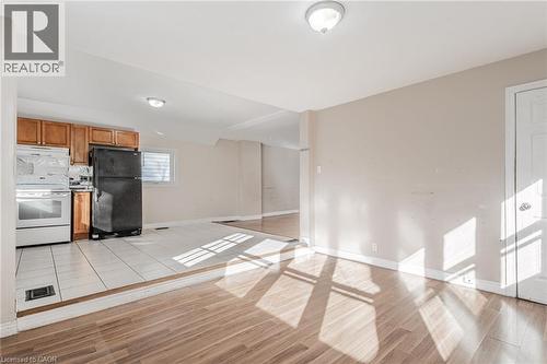 Kitchen with freestanding refrigerator, electric range, light wood-style floors, and wood finish cabinets - 20 East 27Th Street, Hamilton, ON - Indoor Photo Showing Other Room