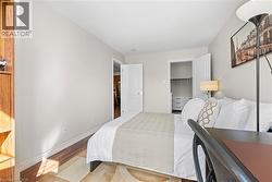 Bedroom with wood finished floors and a walk in closet - 