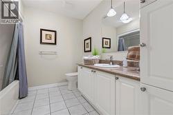 Full bathroom with vanity, light tile patterned floors, and shower / bath combo with shower curtain - 