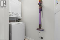Laundry room with stacked washer and clothes dryer and baseboards - 