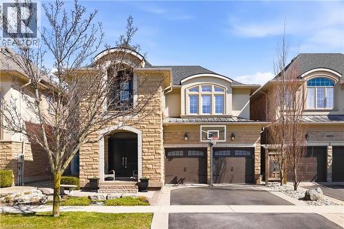 French country home featuring a garage, stone siding, driveway, a standing seam roof, and stucco siding - 4670 Bracknell Road, Burlington, ON - Outdoor With Facade