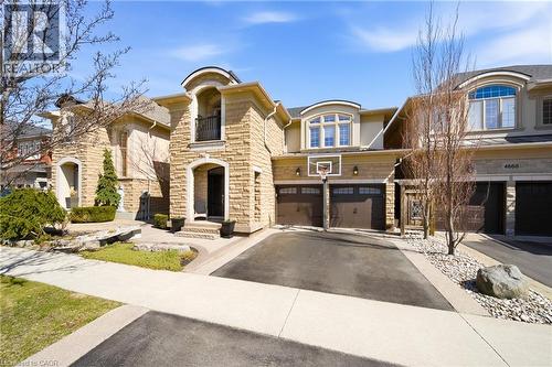 View of front of home with an attached garage, driveway, stone siding, and stucco siding - 4670 Bracknell Road, Burlington, ON - Outdoor With Facade