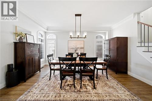 Dining space featuring wood finished floors, ornamental molding, and a chandelier - 4670 Bracknell Road, Burlington, ON - Indoor Photo Showing Dining Room
